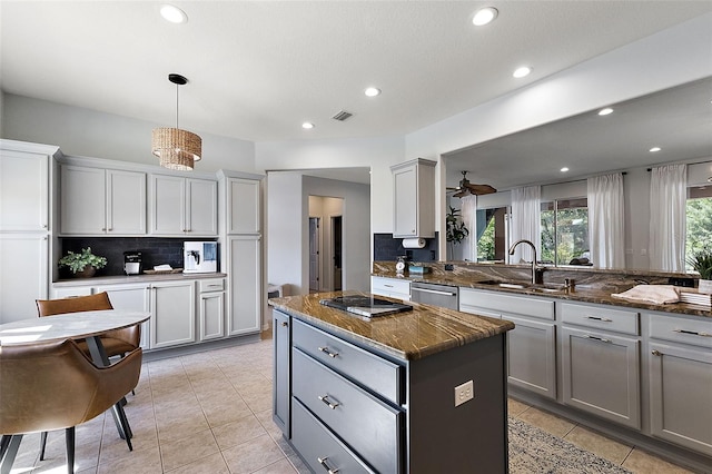 kitchen with visible vents, gray cabinetry, a sink, a kitchen island, and stainless steel dishwasher