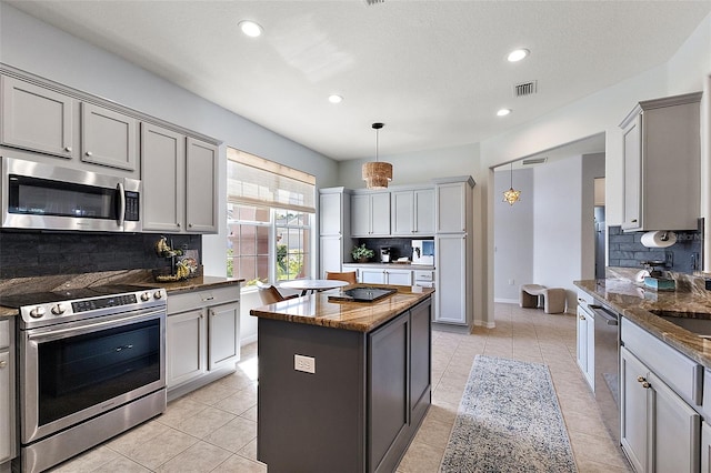 kitchen featuring light tile patterned floors, stainless steel appliances, and gray cabinets