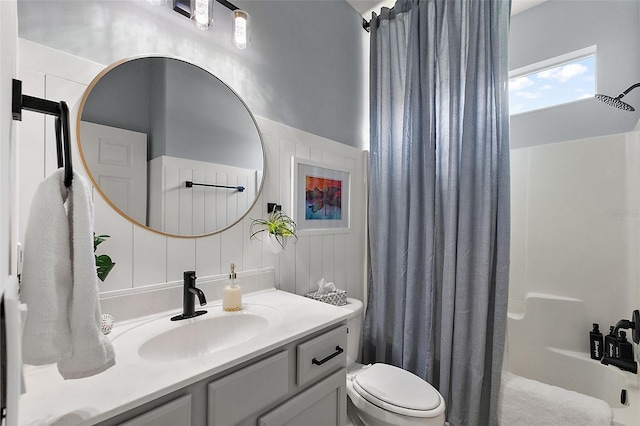 bathroom with toilet, vanity, and a shower with shower curtain