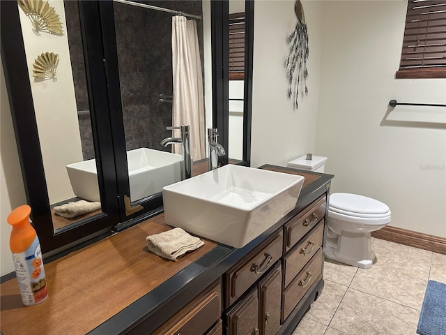 bathroom with baseboards, toilet, a shower with curtain, tile patterned floors, and vanity