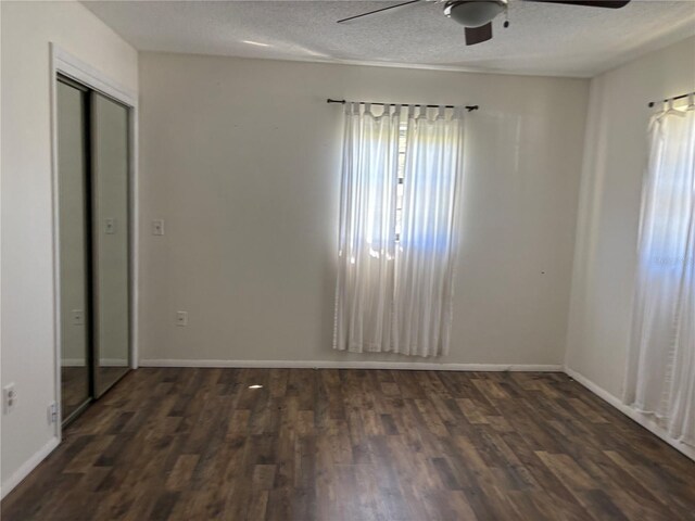 empty room featuring ceiling fan, a textured ceiling, baseboards, and wood finished floors