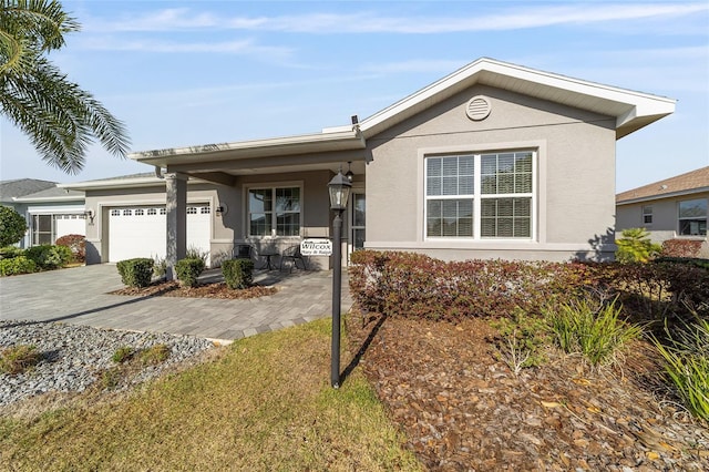 single story home with stucco siding, driveway, and a garage