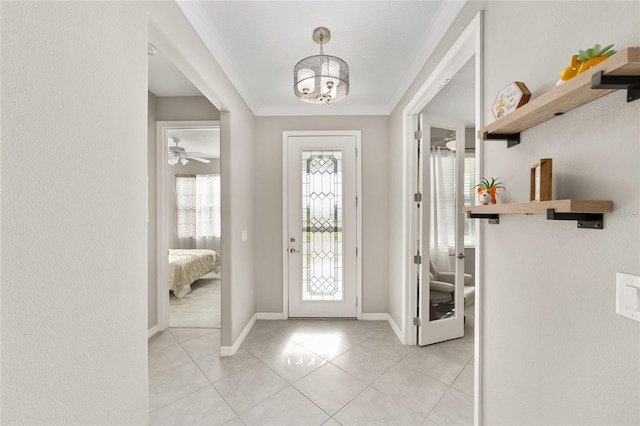 foyer with light tile patterned floors, baseboards, a chandelier, and crown molding