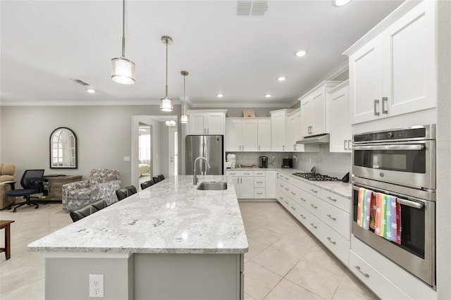 kitchen with a sink, visible vents, under cabinet range hood, and stainless steel appliances