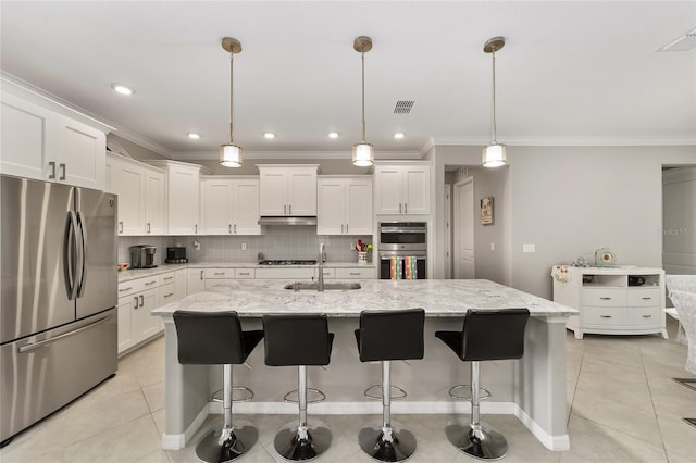 kitchen with white cabinets, tasteful backsplash, appliances with stainless steel finishes, and a sink