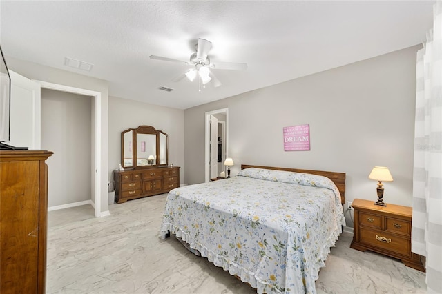 bedroom with a ceiling fan, visible vents, marble finish floor, and baseboards