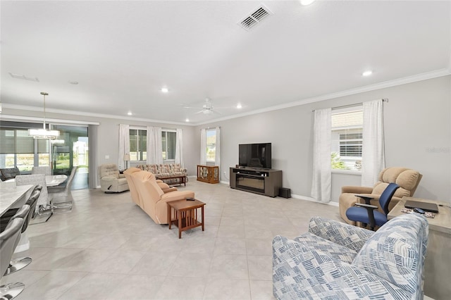 living room featuring a ceiling fan, a wealth of natural light, ornamental molding, and visible vents