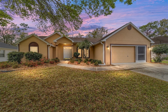 ranch-style home with a garage, a front yard, concrete driveway, and stucco siding