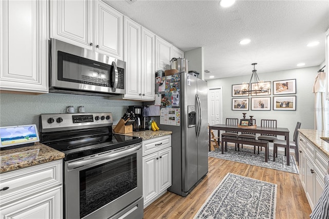 kitchen featuring appliances with stainless steel finishes, light wood-type flooring, and white cabinets