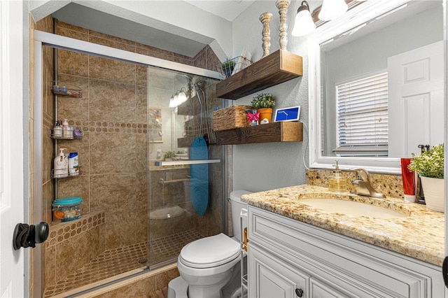 bathroom featuring a stall shower, vanity, and toilet