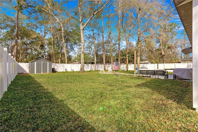 view of yard with a fenced backyard, an outdoor structure, and a storage shed