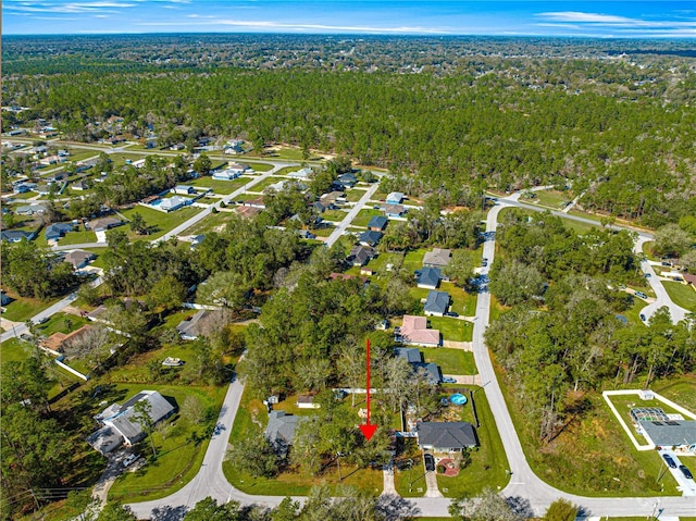 drone / aerial view featuring a residential view and a forest view