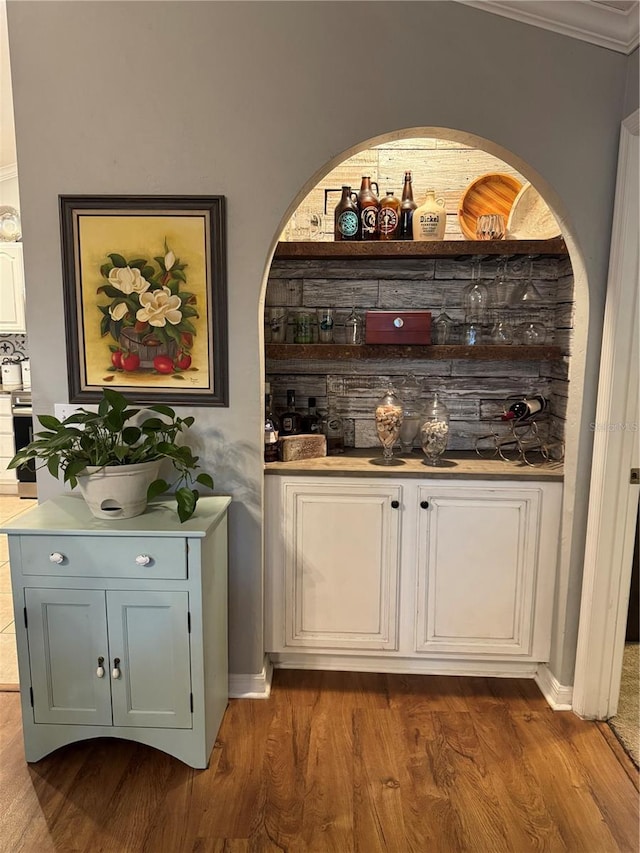 bar featuring dark wood finished floors, a bar, and stainless steel electric stove