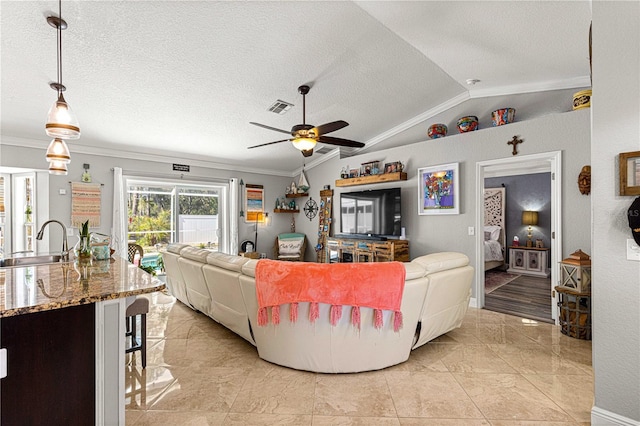 living area featuring visible vents, ornamental molding, ceiling fan, vaulted ceiling, and a textured ceiling