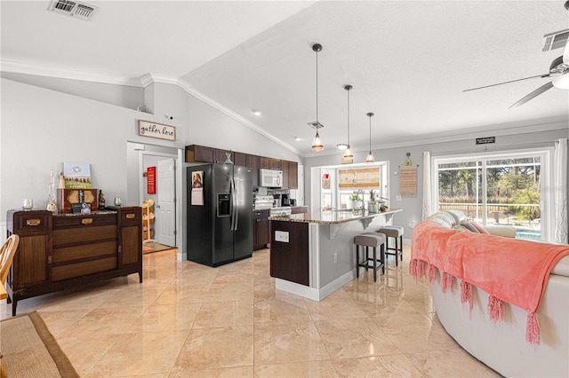 kitchen featuring visible vents, black fridge with ice dispenser, open floor plan, a breakfast bar area, and white microwave