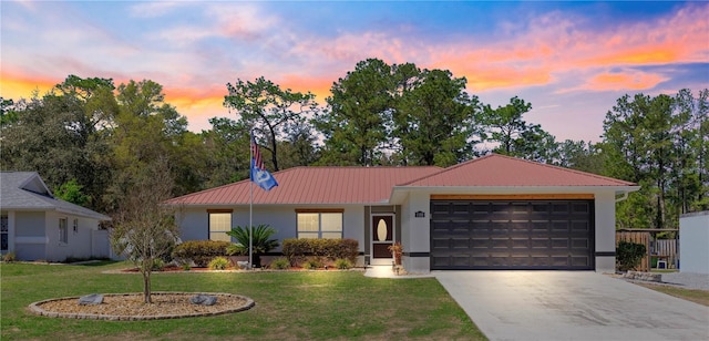 single story home with a yard, a garage, driveway, and metal roof