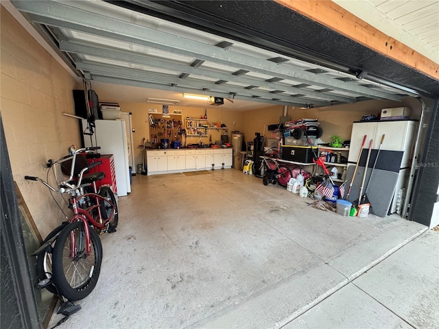 garage with a workshop area, a garage door opener, and concrete block wall