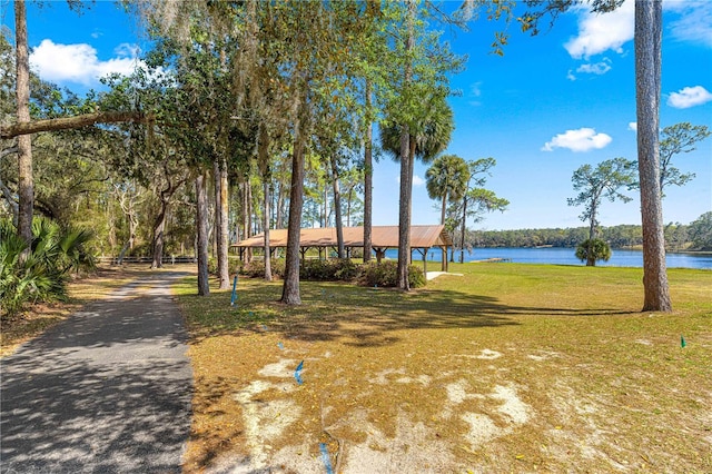 exterior space featuring driveway, a front yard, and a water view