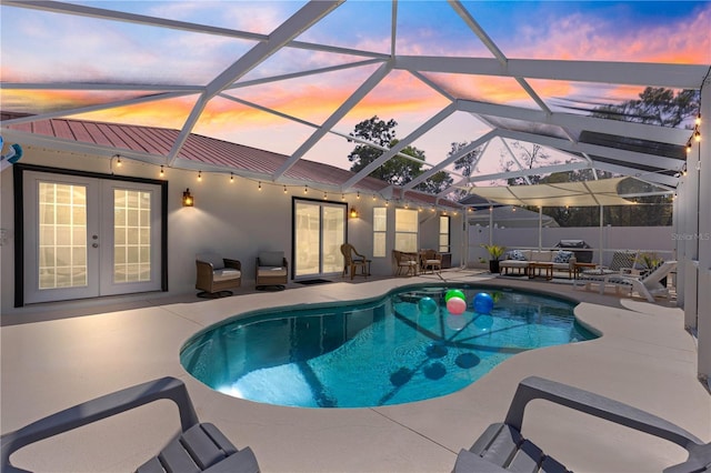 1192 NE 130th Ter, Silver Springs, FL 34488 - pool at dusk with french doors, a patio area, an outdoor living space, and a lanai