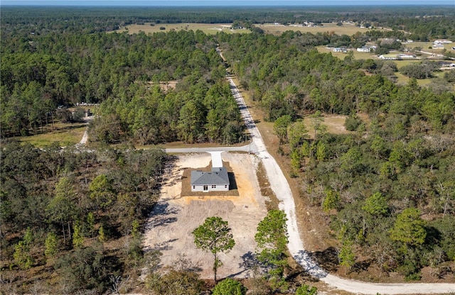 bird's eye view with a wooded view