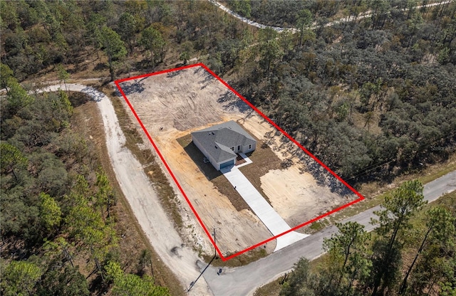 birds eye view of property with a forest view