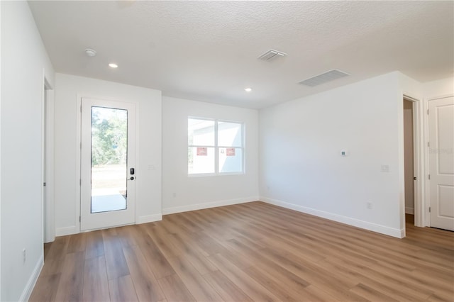 interior space featuring recessed lighting, visible vents, light wood-style flooring, and baseboards