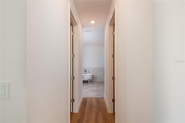 hallway with recessed lighting, visible vents, and wood finished floors