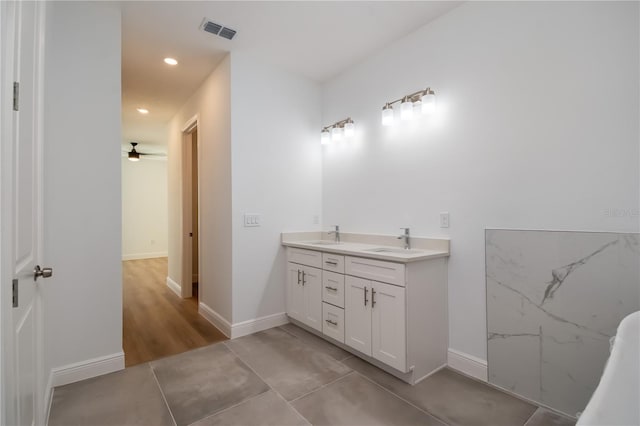 bathroom with double vanity, recessed lighting, visible vents, a sink, and baseboards