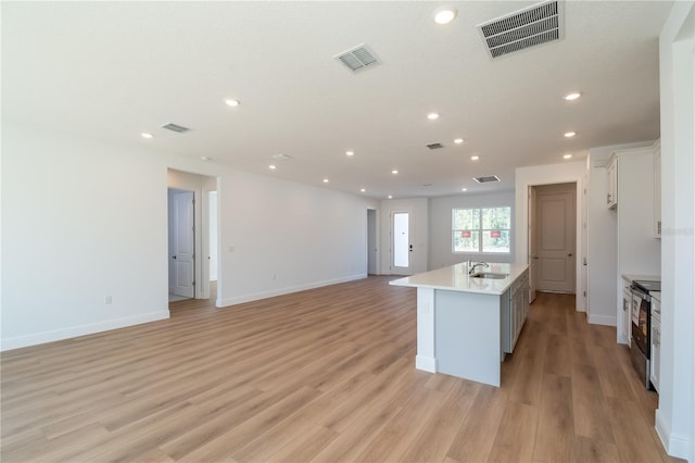 kitchen featuring light wood finished floors, electric range, and visible vents