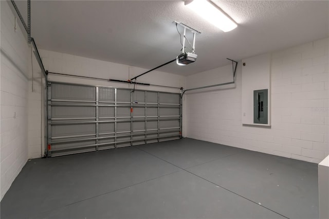 garage with concrete block wall, electric panel, and a garage door opener