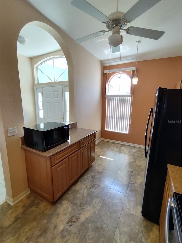 kitchen with baseboards, hanging light fixtures, black appliances, and ceiling fan