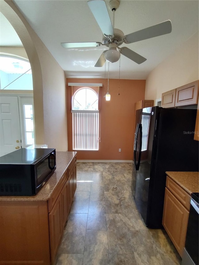 kitchen featuring black appliances, ceiling fan, arched walkways, and a center island