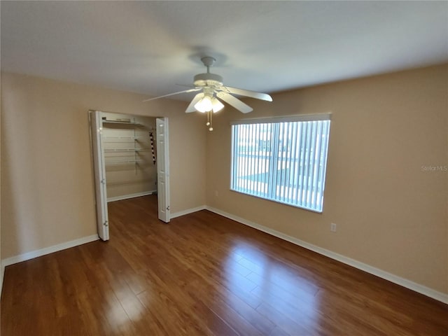 spare room with a ceiling fan, baseboards, and wood finished floors