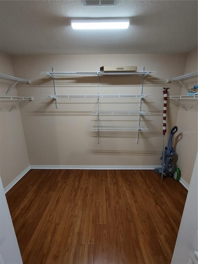 walk in closet with wood finished floors