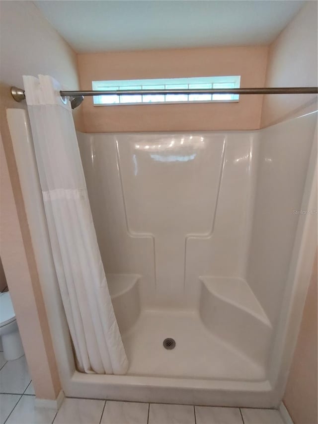 bathroom featuring a shower stall and toilet