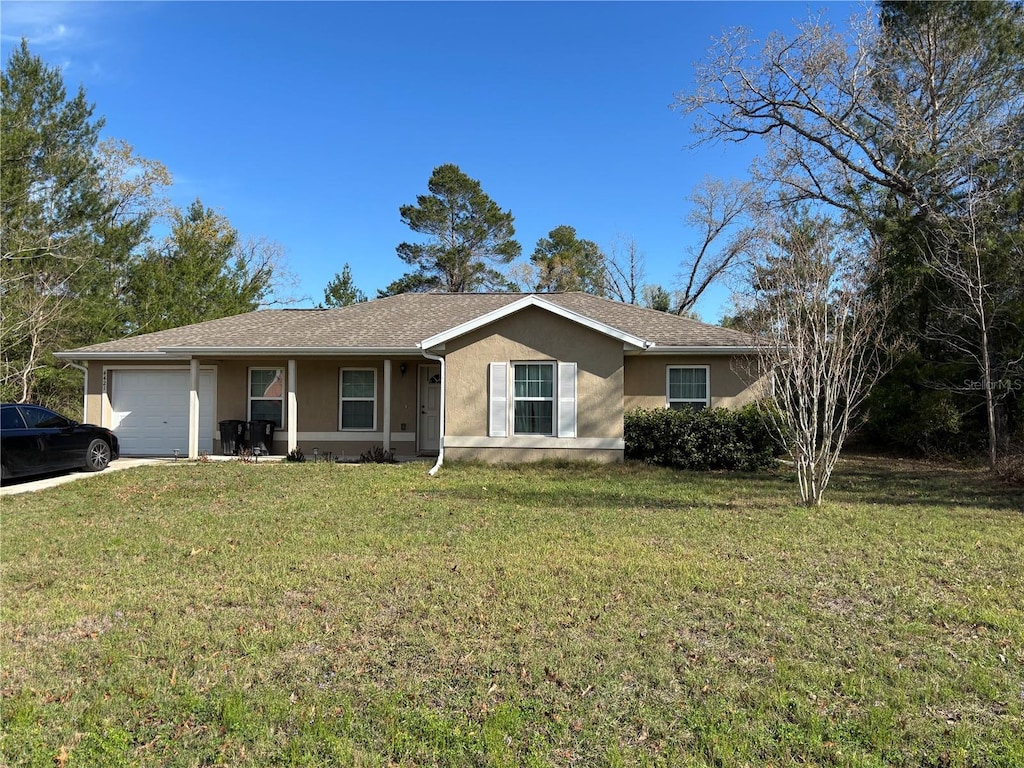 ranch-style house with stucco siding, a front yard, and an attached garage