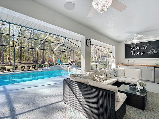 outdoor pool featuring ceiling fan, a lanai, a patio area, and an outdoor hangout area