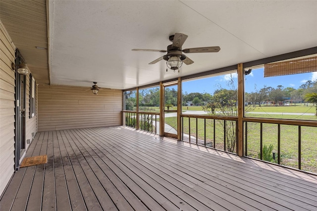 wooden terrace with a lawn and ceiling fan