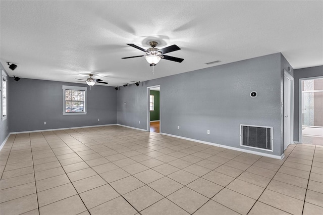 unfurnished room featuring baseboards, visible vents, a textured ceiling, and ceiling fan