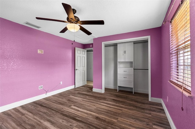 unfurnished bedroom with visible vents, baseboards, a closet, and dark wood-style floors