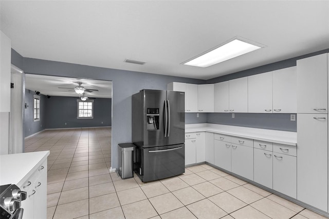 kitchen featuring visible vents, stainless steel fridge, white cabinets, light tile patterned flooring, and light countertops