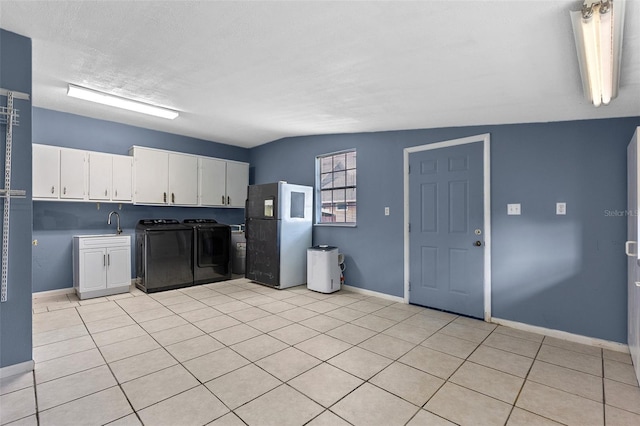 kitchen featuring light tile patterned floors, baseboards, separate washer and dryer, freestanding refrigerator, and white cabinets