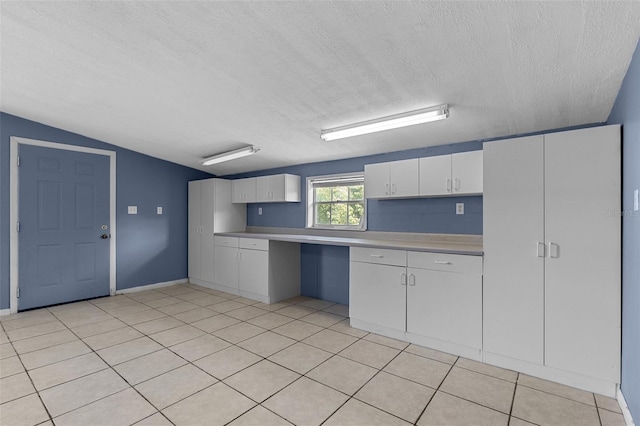 kitchen featuring light countertops, white cabinets, and a textured ceiling