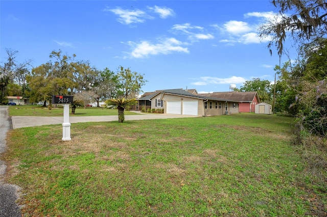 view of yard featuring a garage and concrete driveway