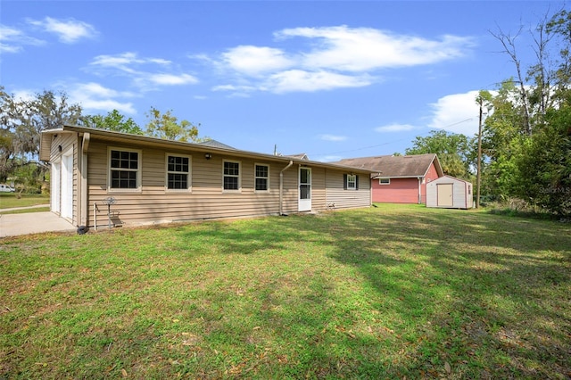 view of front of home with a shed, a lawn, an outdoor structure, and a garage