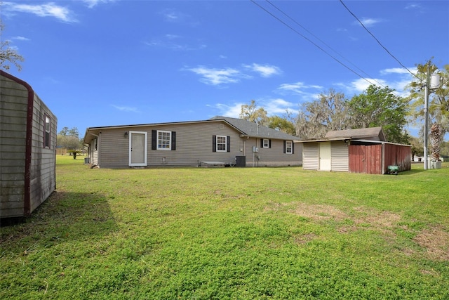 rear view of house with a yard, central air condition unit, a storage shed, and an outdoor structure