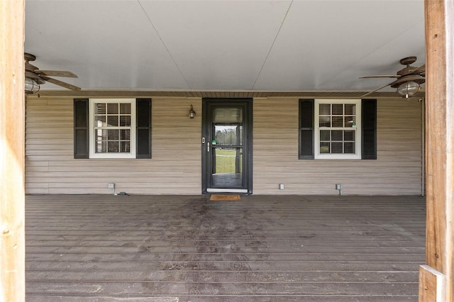 wooden deck featuring covered porch and ceiling fan