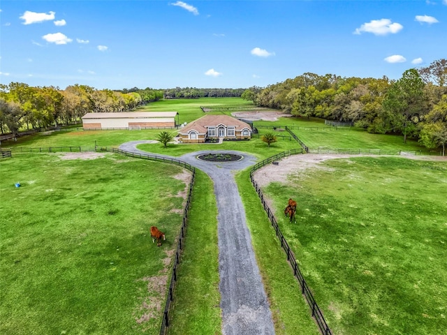 surrounding community with a rural view, fence, and a lawn