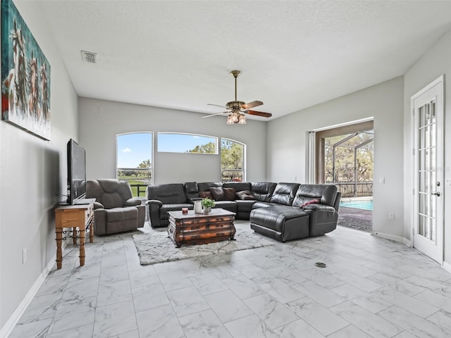 living room with marble finish floor, baseboards, visible vents, and a textured ceiling