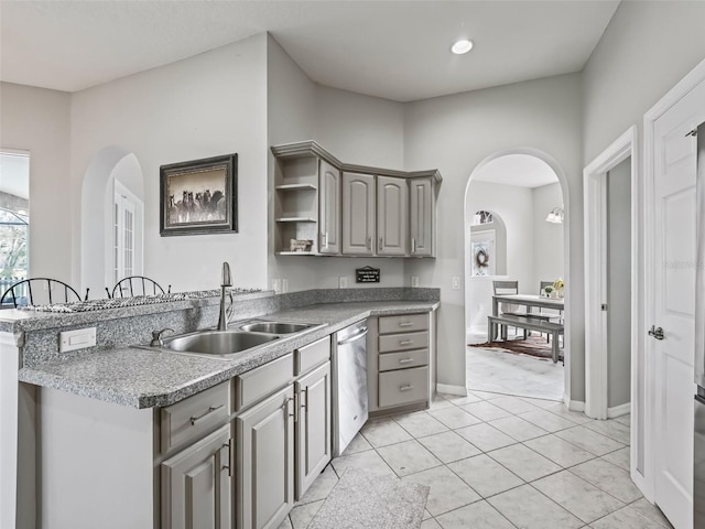 kitchen featuring arched walkways, open shelves, gray cabinetry, a sink, and dishwasher